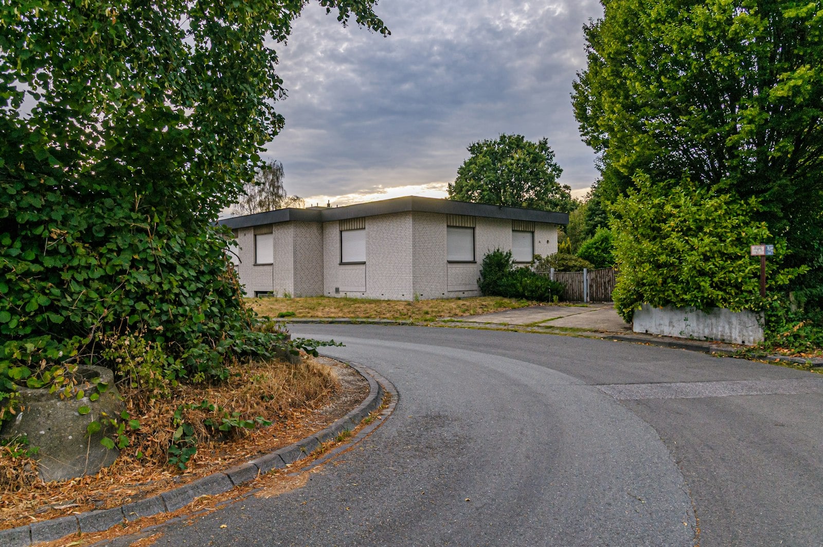 Single-story brick house with shutters on a quiet street