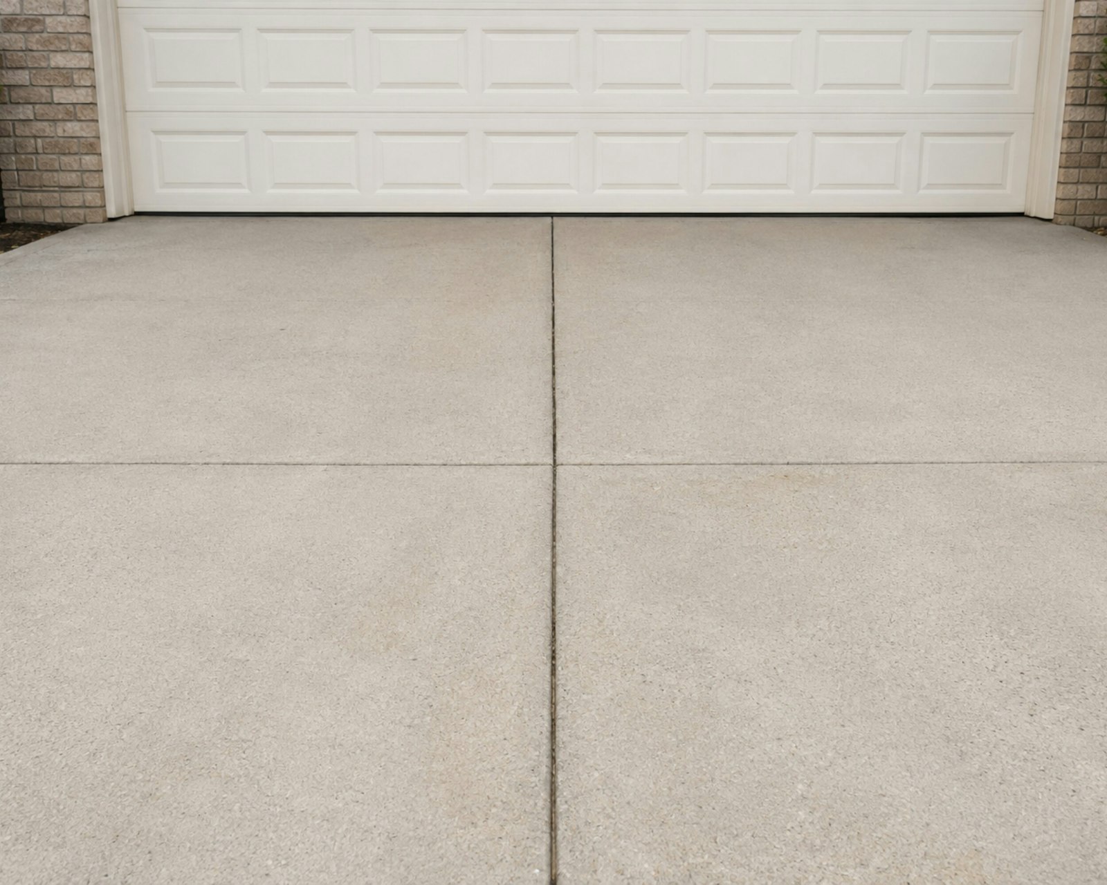 Concrete driveway slab in front of a white house